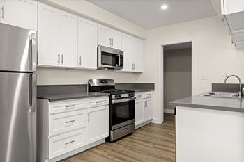 A modern kitchen with white cabinets and stainless steel appliances.